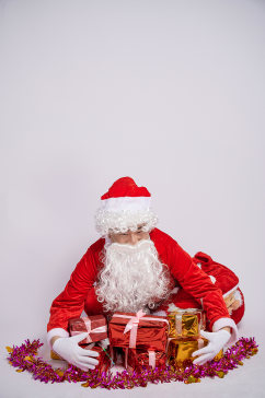 圣诞节圣诞老人坐姿圣诞礼物堆人物摄影图