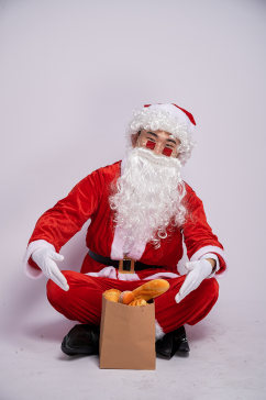 圣诞节圣诞老人坐着展示面包人物摄影图