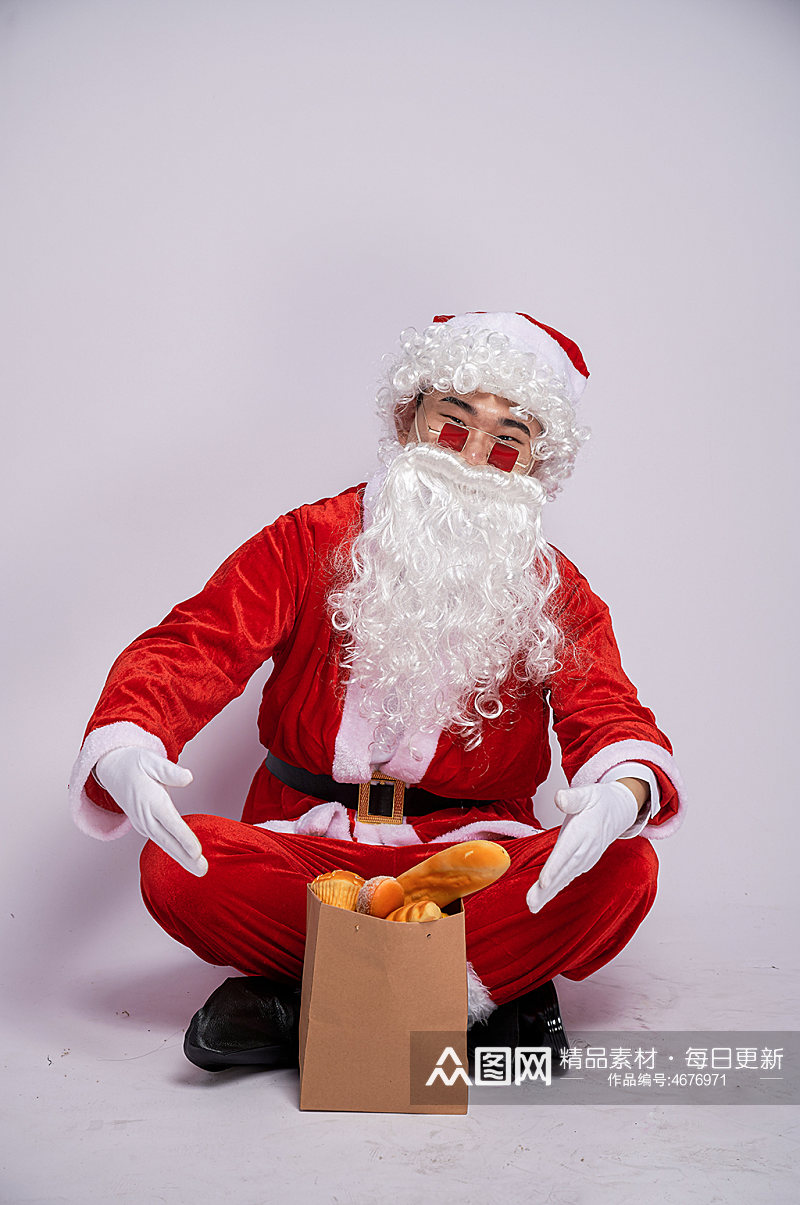 圣诞节圣诞老人坐着展示面包人物摄影图素材