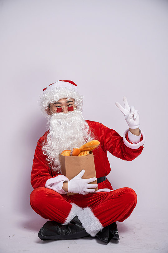 圣诞节圣诞老人坐着拿面包人物摄影图