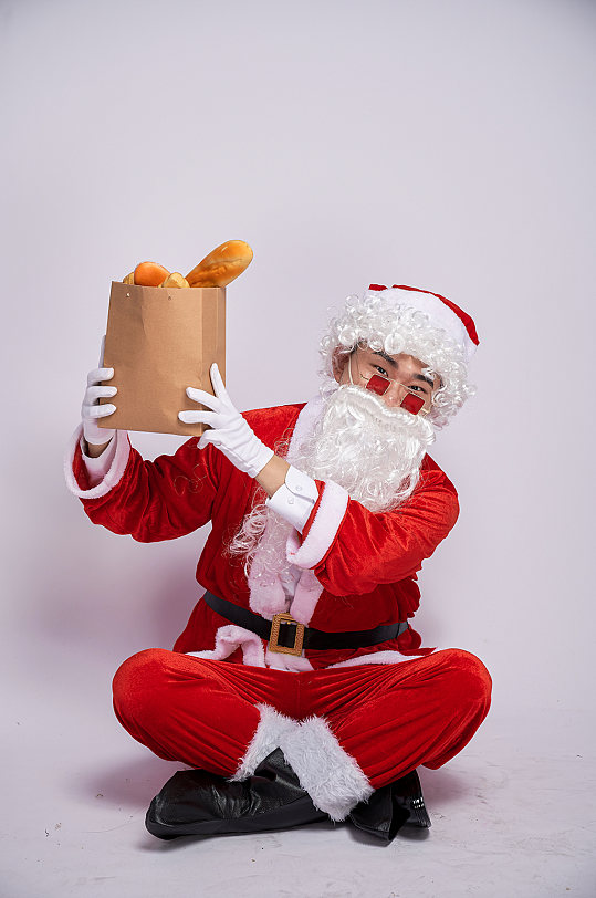 圣诞节圣诞老人坐着手举面包人物摄影图