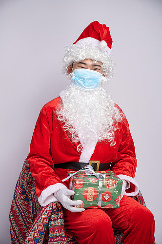 圣诞节圣诞老人带口罩坐姿人物摄影图