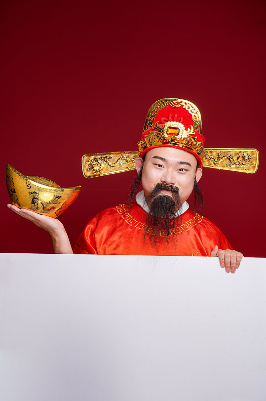 国潮新年财神爷手持金元宝人物摄影图