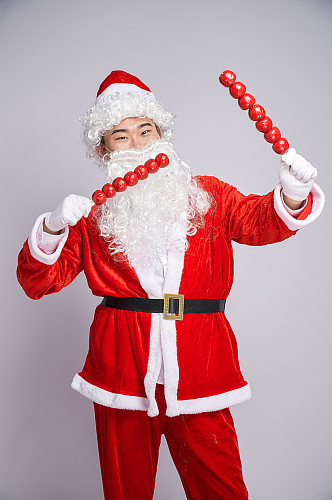 圣诞节圣诞老人站着手拿糖葫芦人物摄影图