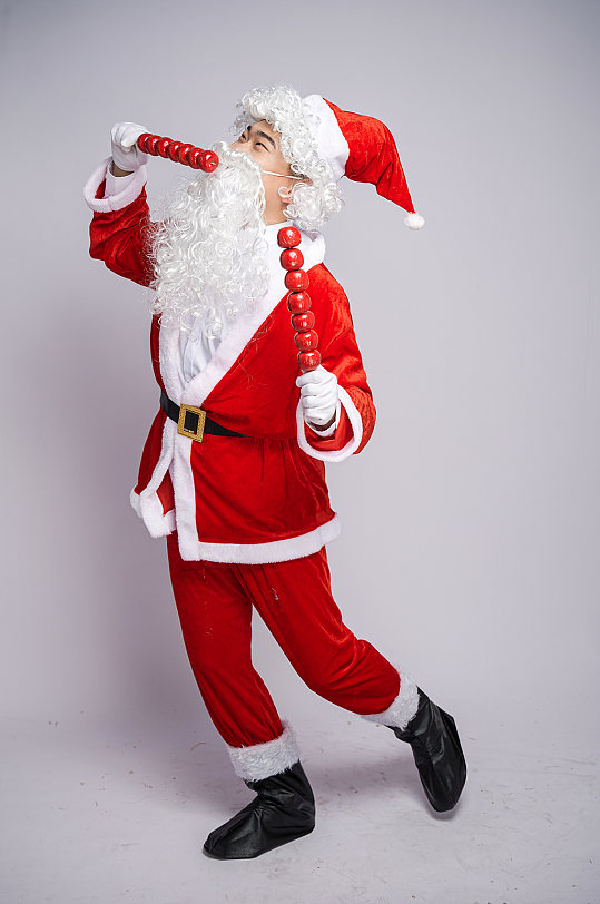圣诞节圣诞老人侧身手拿糖葫芦人物摄影图