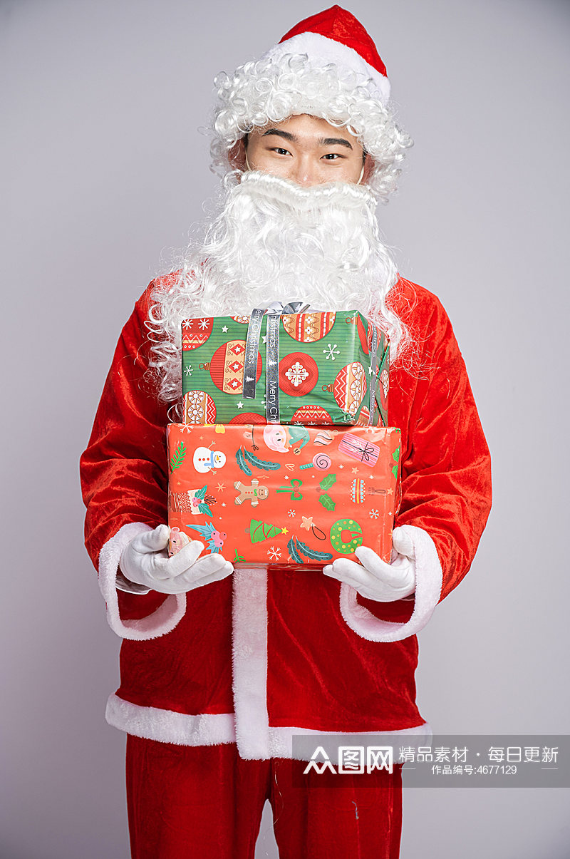 圣诞节圣诞老人站着怀抱礼物盒人物摄影图素材