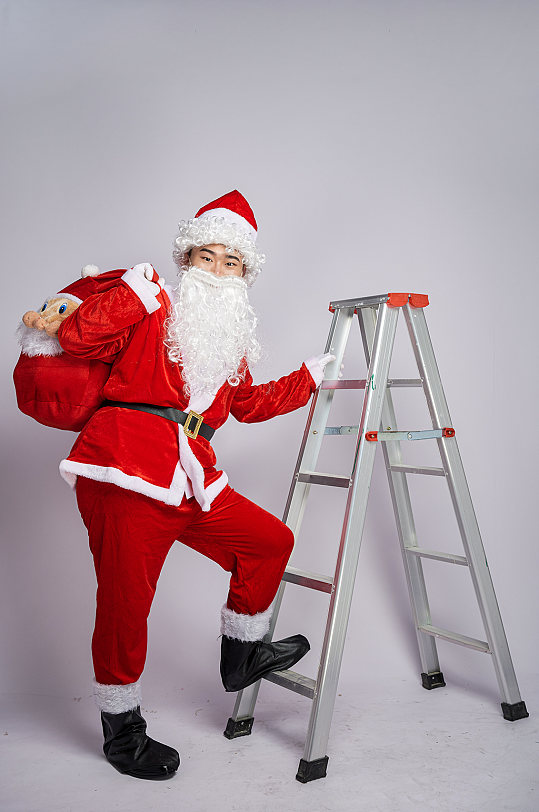 圣诞节圣诞老人爬梯子人物摄影图