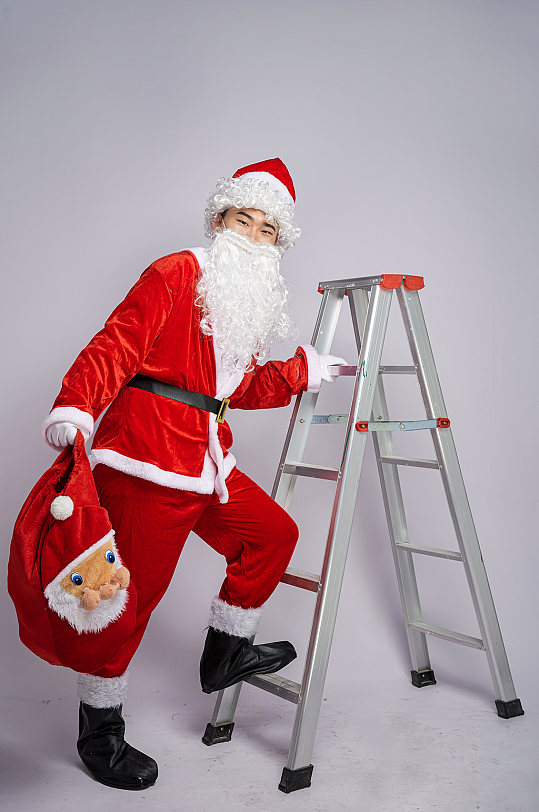 圣诞节圣诞老人爬梯子人物摄影图