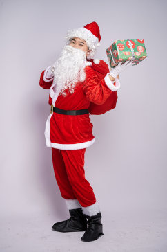 圣诞老人背礼物袋手拿礼物盒人物摄影图