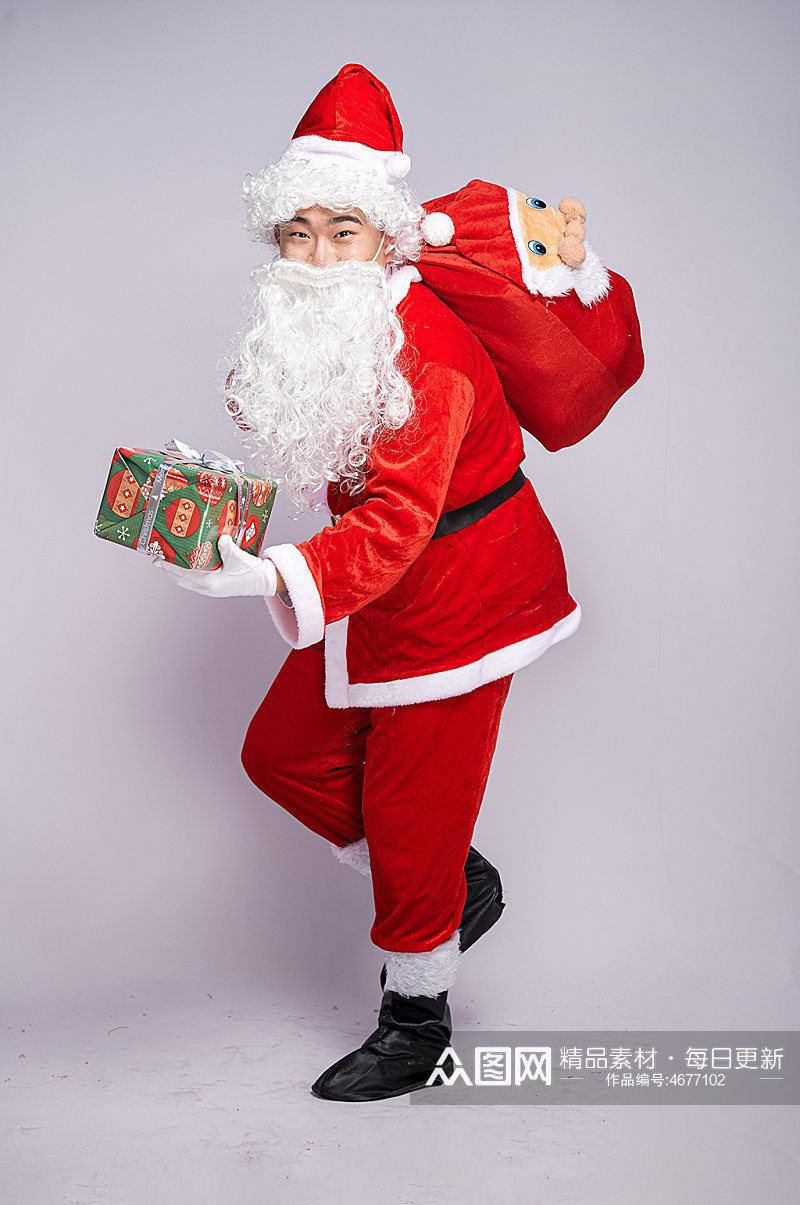 圣诞老人背礼物袋手拿礼物盒人物摄影图素材