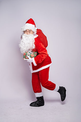 圣诞节圣诞老人背礼物手拿礼物袋人物摄影图