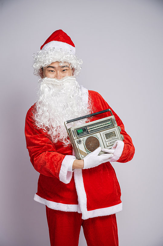 圣诞节圣诞老人站着手拿音箱人物摄影图