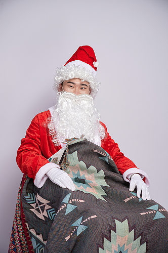 圣诞节圣诞老人坐椅子盖毯子人物摄影图