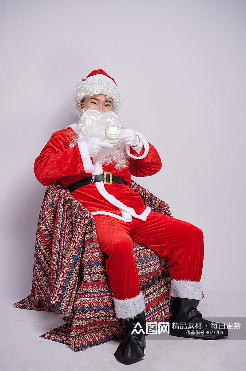 圣诞节圣诞老人坐椅子喝咖啡人物摄影图素材