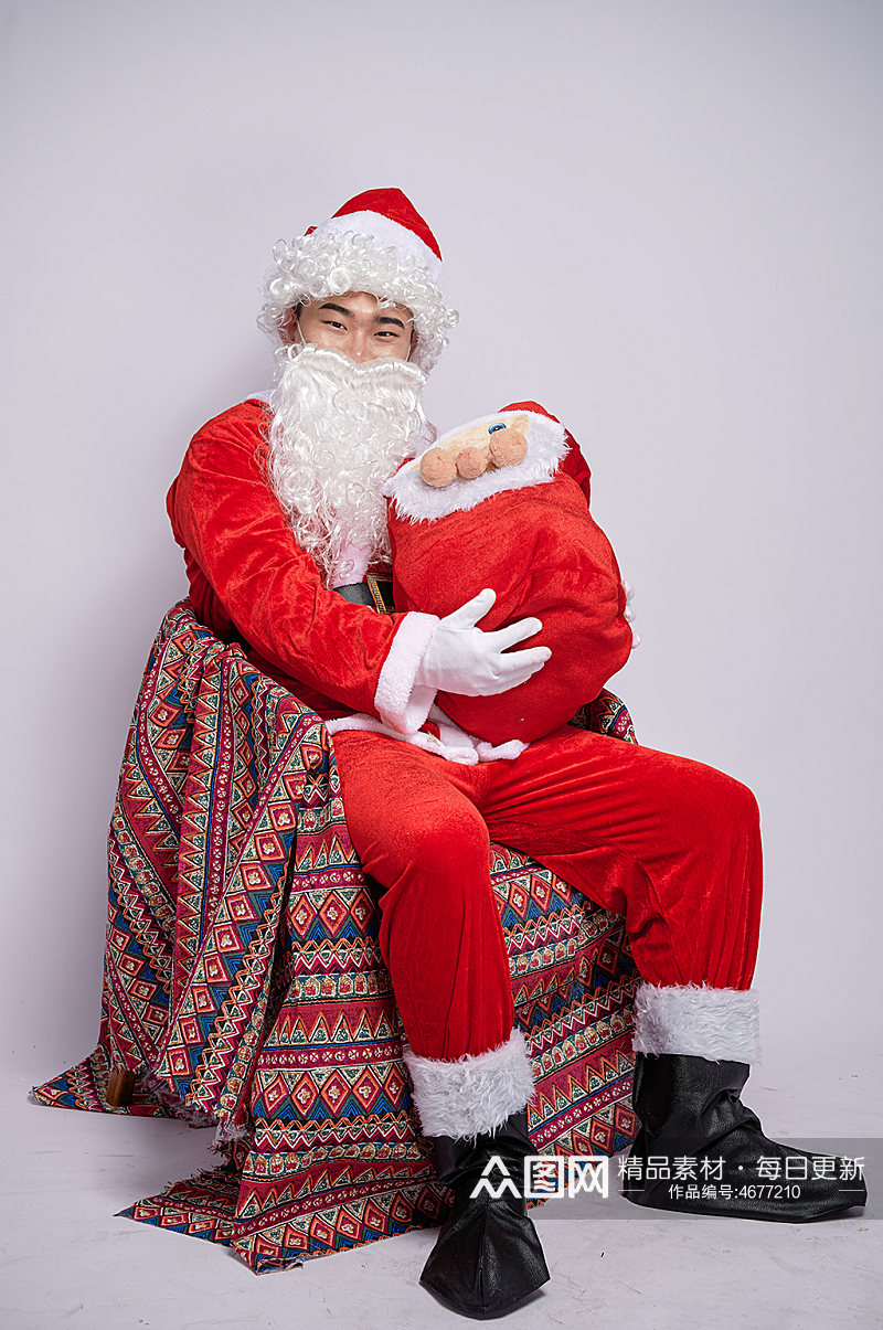 圣诞节圣诞老人坐椅子抱礼物人物摄影图素材