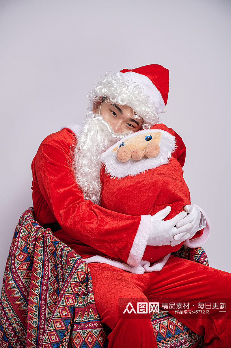 圣诞节圣诞老人坐椅子抱礼物人物摄影图素材