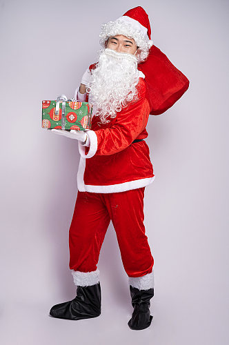 圣诞节圣诞老人站着背礼物拿礼物人物摄影图