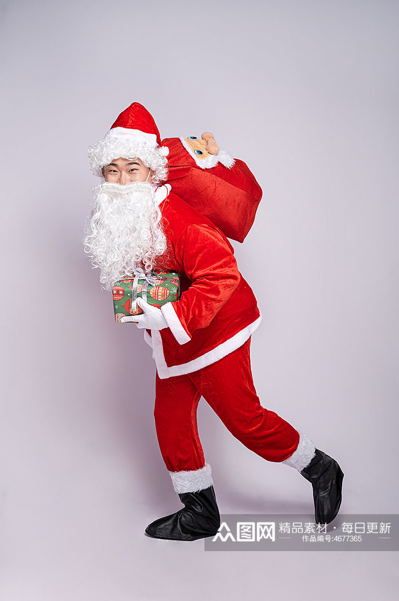圣诞节圣诞老人弯腰背礼物拿礼物人物摄影图素材