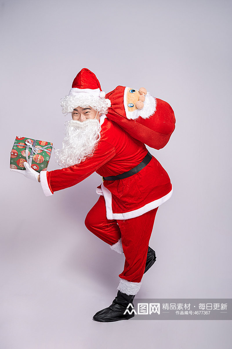 圣诞节圣诞老人弯腰背礼物拿礼物人物摄影图素材
