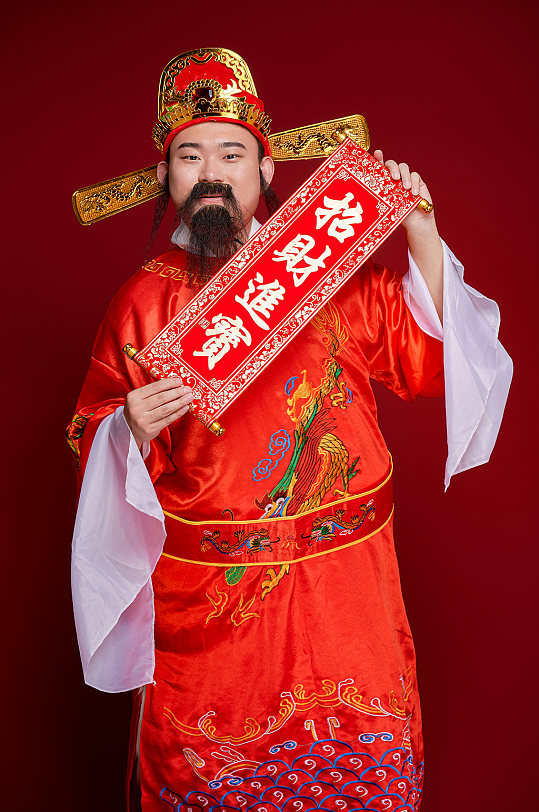 新年财神爷手拿春联对联人物摄影图