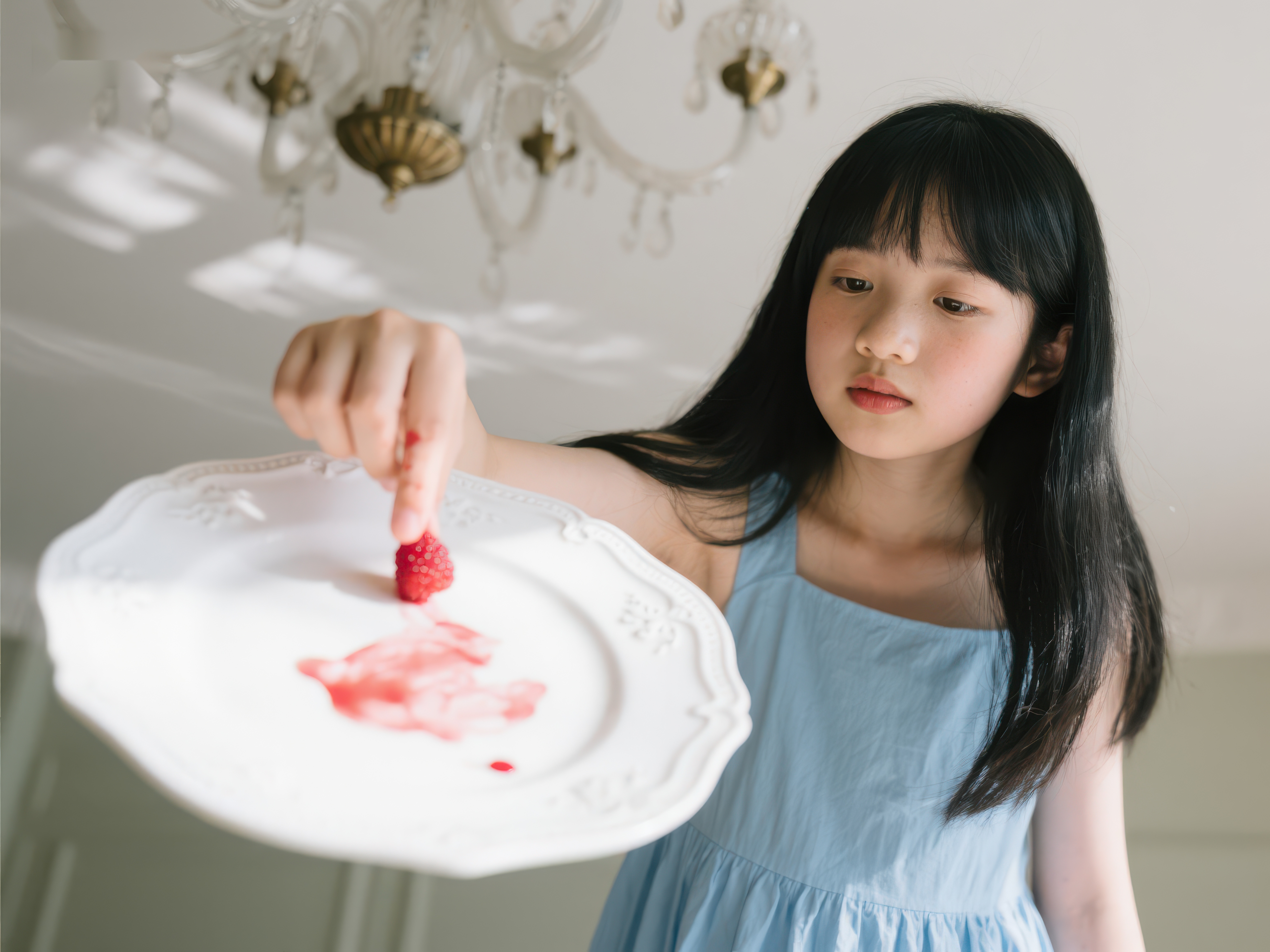 小女孩手持盘子轻放草莓素材