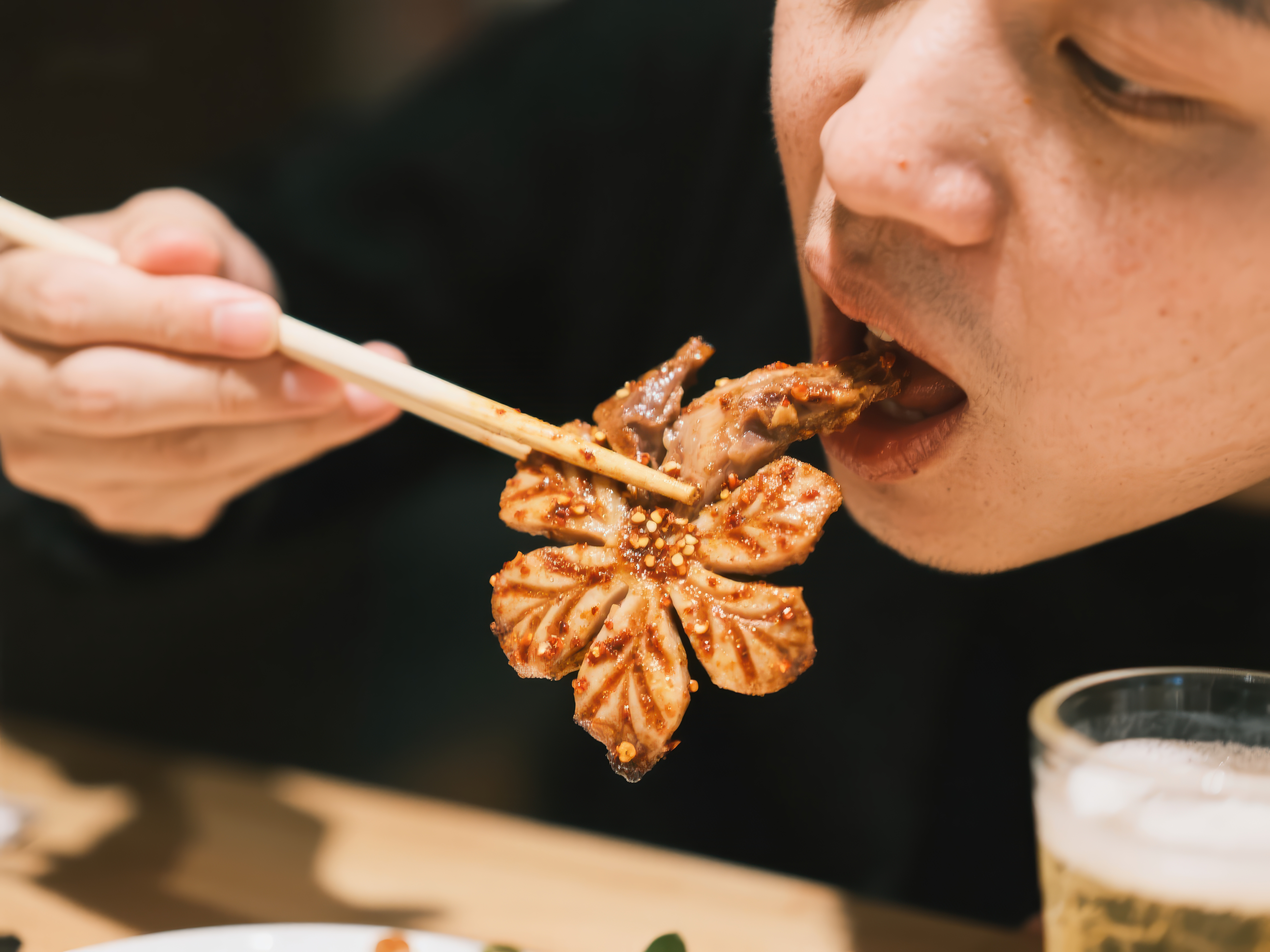 享用美味烤肉筷子夹起花形食物素材