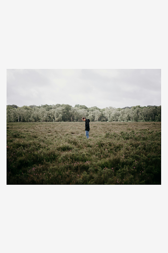 一人站在开阔草地上远眺-众图网