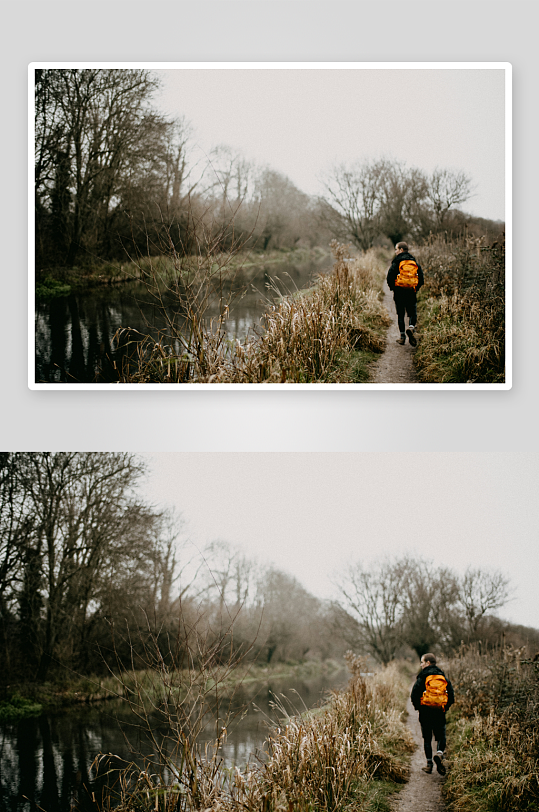 一人背着橙色背包在河边小径行走-众图网