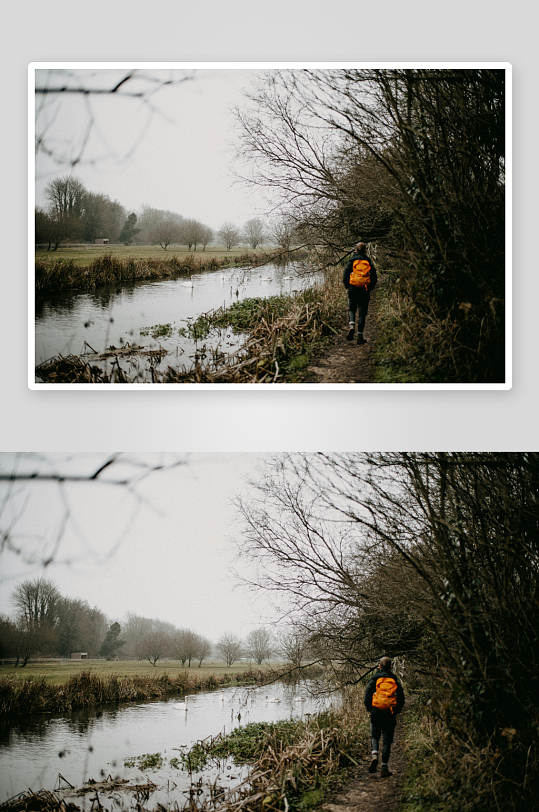 一人背着橙色背包沿河小径行走-众图网