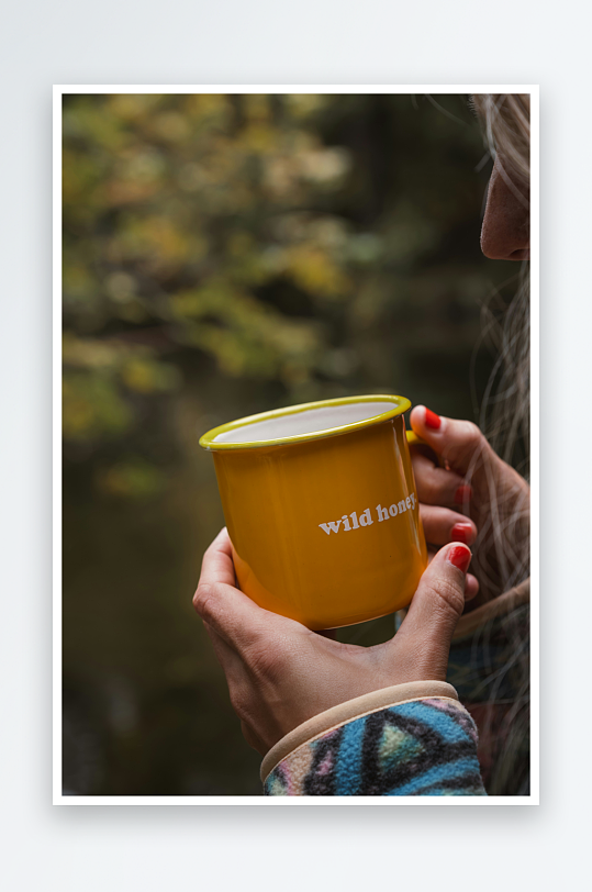 女子手持黄色杯子户外饮茶-众图网