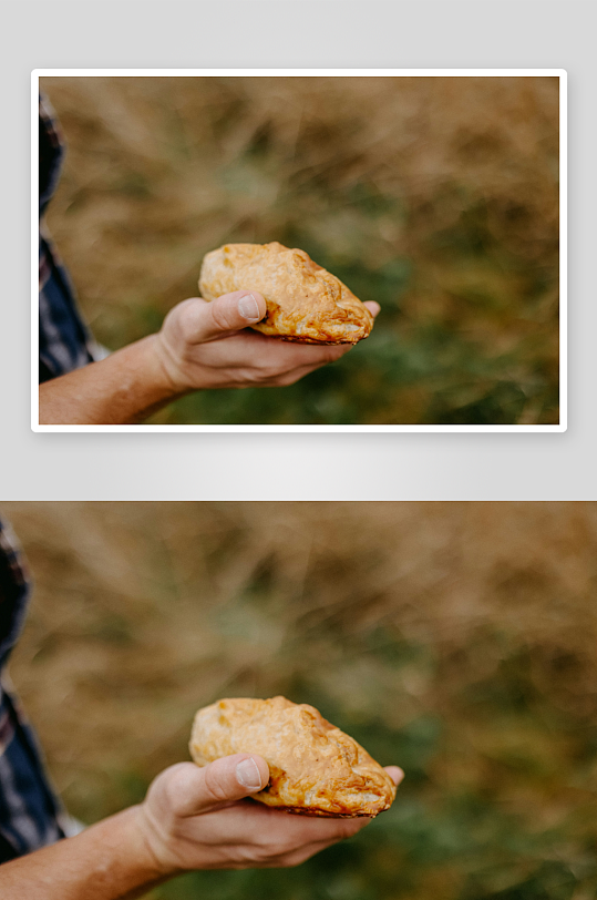 手中捧着一块金黄色的面包-众图网