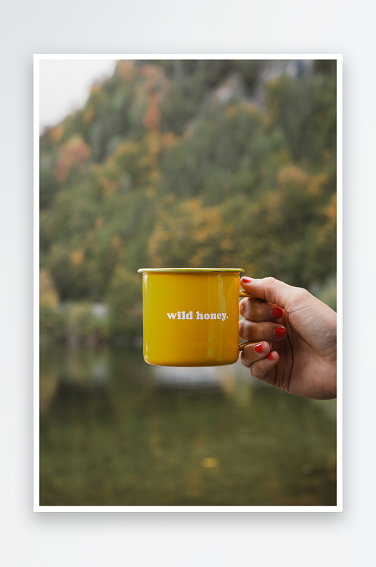 手持黄色杯子的自然风光-众图网