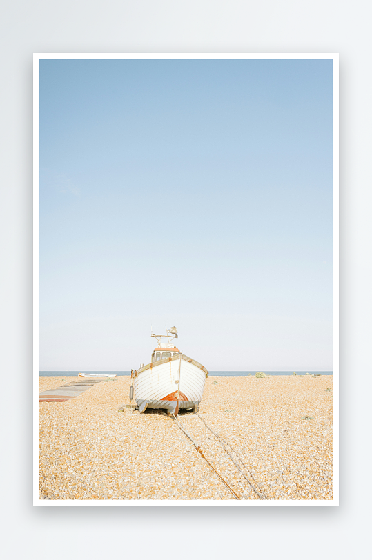 搁浅在鹅卵石滩上的白色渔船-众图网