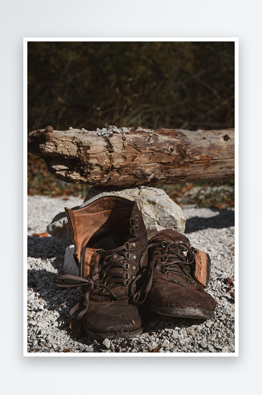 旧登山靴置于石砾与枯木旁-众图网