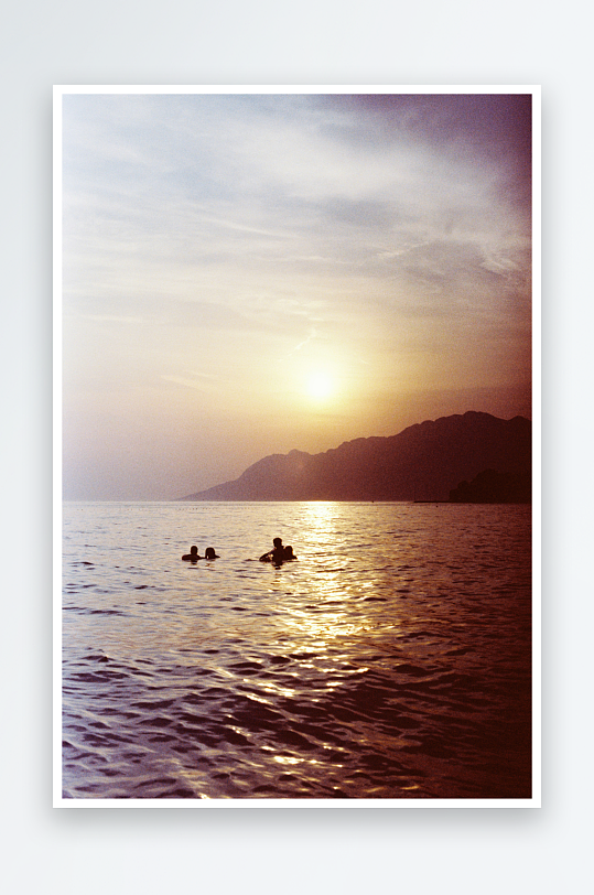 夕阳下湖面游泳的人影-众图网