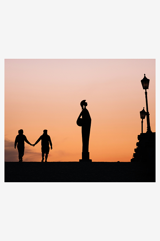 夕阳下牵手的儿童与雕像剪影-众图网