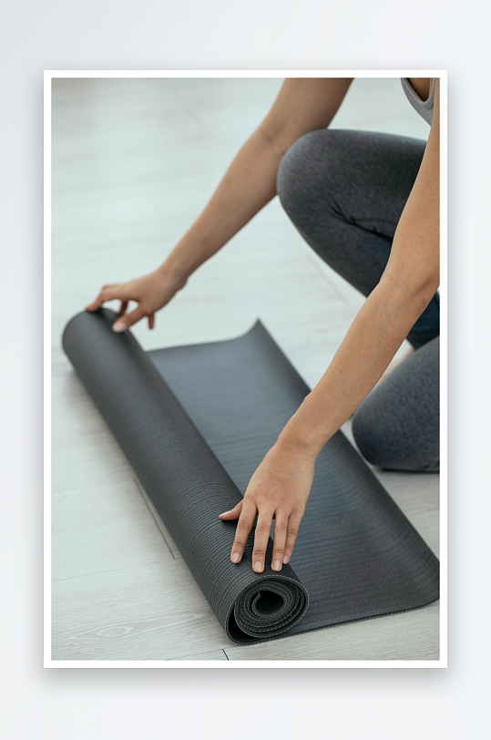 女子卷瑜伽垫准备运动-众图网