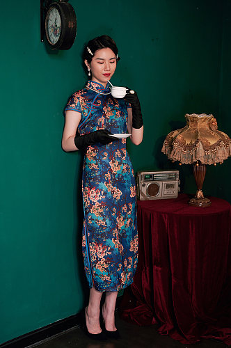 中式旗袍女性手拿杯子商业摄影图片