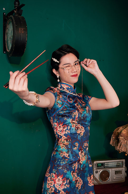 国潮旗袍女性拿筷子商业摄影图照片