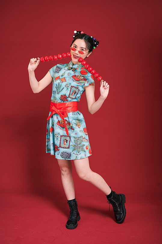 旗袍国潮美女拿糖葫芦造型商业摄影图