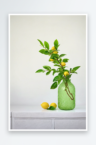 柠檬树枝插绿色玻璃花瓶里图片
